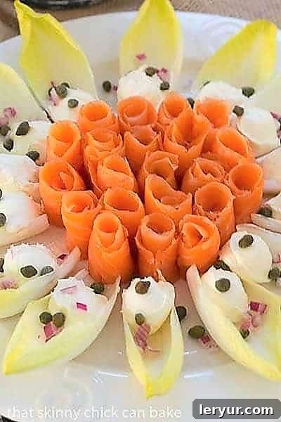 Close-up view of elegant Smoked Salmon Roses with Endive and Creme Fraiche on a detailed smoked salmon platter, highlighting the texture and garnishes.