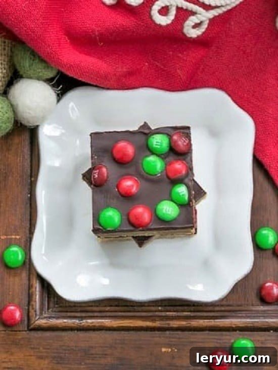 Overhead view of a small white plate filled with colorful Candy Topped Toffee Squares, ready to be enjoyed.