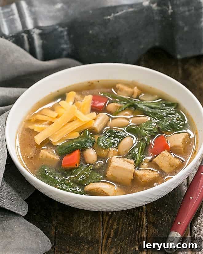 A steaming bowl of White Chicken Chili, garnished beautifully with fresh ingredients, promises a comforting and flavorful meal. Perfect for chilly evenings or lively game days.