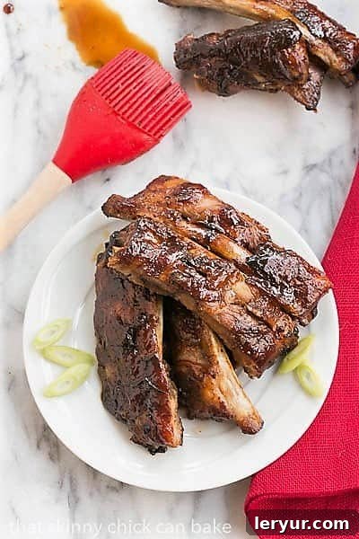 Asian Baby Back Ribs - Finger licking good with a seriously delicious glaze! Overhead view of Oven Baked Asian Baby Back Ribs on a small white plate.