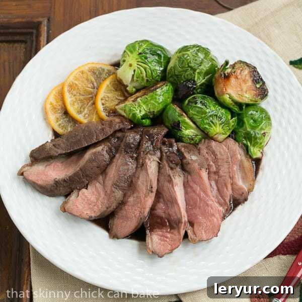 Golden-Crisp Duck Breasts with Clementine Drizzle 2 Pan Seared Duck Breasts arranged on a plate with orange slices and roasted Brussels sprouts.