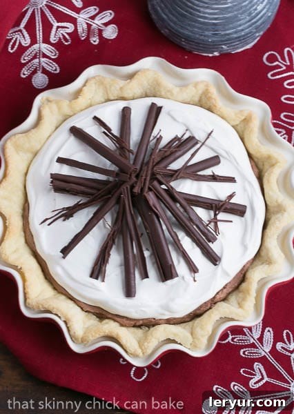 Black Bottom Chocolate Mousse Pie - a decadent dessert sensation! An overhead view of a beautifully garnished Black Bottom Chocolate Mousse Pie resting on a festive red and white checkered cloth, inviting a slice.