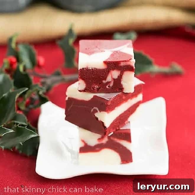 Red Velvet Fudge - This marbleized fudge will make you swoon! This easy fudge recipe is perfect for the holidays! Red Velvet Fudge on a small square rippled plate.