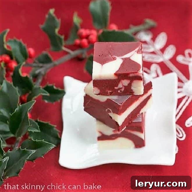 Easy Red Velvet Delight 3 Stack of red velvet fudge on a small white plate with holly berries.