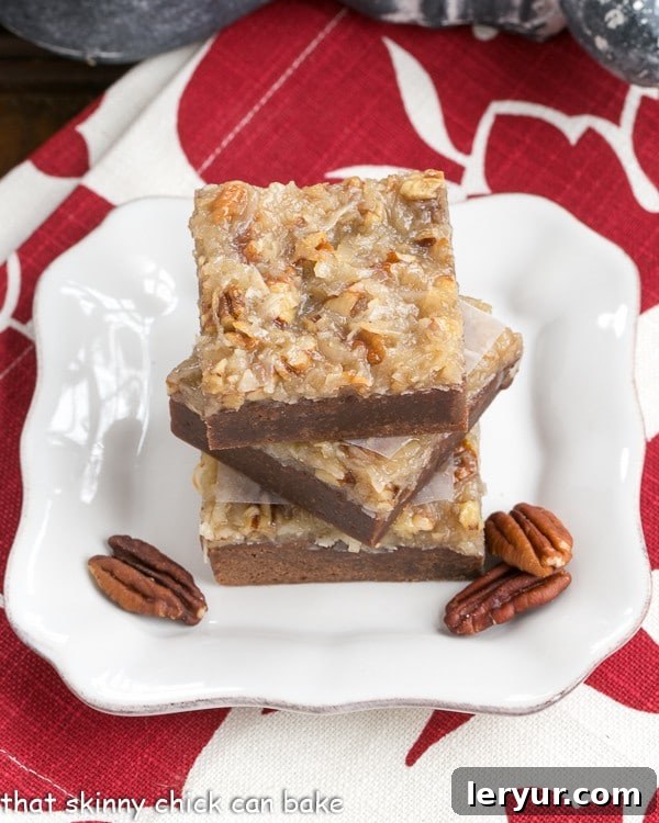 German Chocolate Brownies - fudgy brownies with a gooey pecan coconut topping German Chocolate Brownies on a square white plate with pecan halves. A close-up shot showcasing the rich chocolate brownie base and the golden-brown coconut pecan topping.