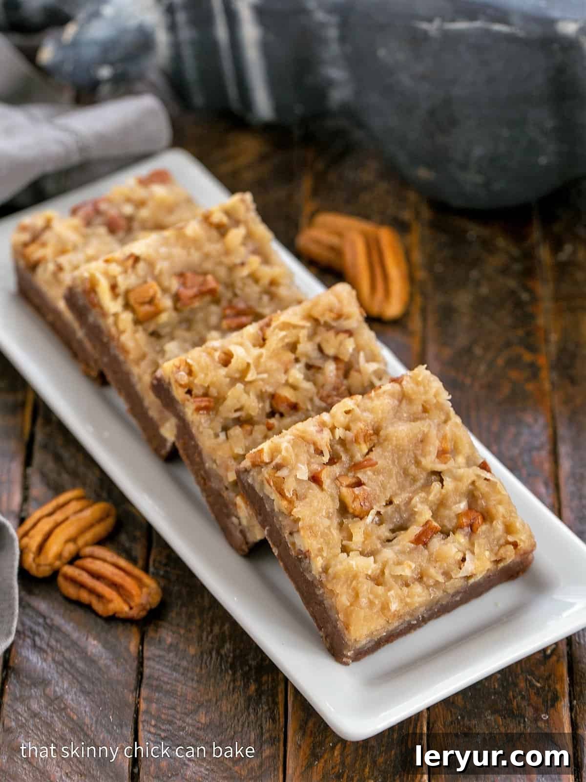 Coconut Pecan Delight Brownies 2 4 German Chocolate Brownies on a white tray, showcasing their perfect square shapes and the rich, bubbly topping.