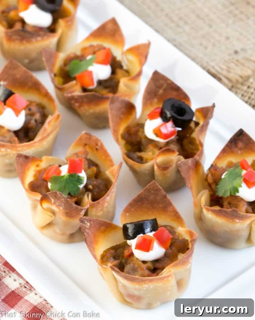 Mini Mexican Tarts - Crispy Shells filled with spiced sausage and cheese create delicious, spicy sausage appetizers Mini Mexican Tarts neatly lined up on a white tray, ready to be served at a party.