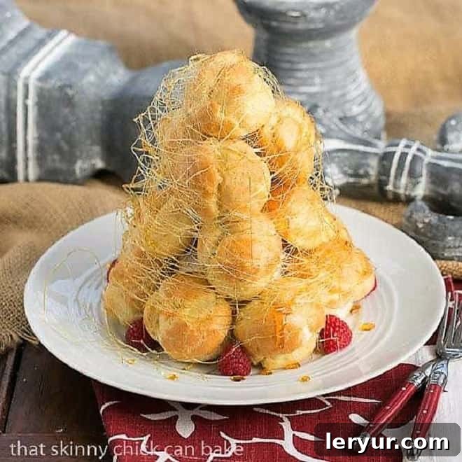 A majestic Lemon Cream Croquembouche stands proudly on a pristine white serving plate, adorned with vibrant fresh raspberries and delicate spun sugar. This towering dessert is a testament to sophisticated French patisserie.