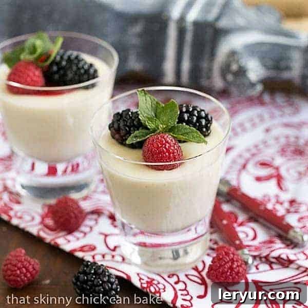 Cooked Cream AKA Panna Cotta is a luscious, tasty Italian dessert Two beautifully plated servings of Vanilla Bean Panna Cotta, generously garnished with a vibrant assortment of fresh berries and a delicate sprig of mint, highlighting its inviting appeal.