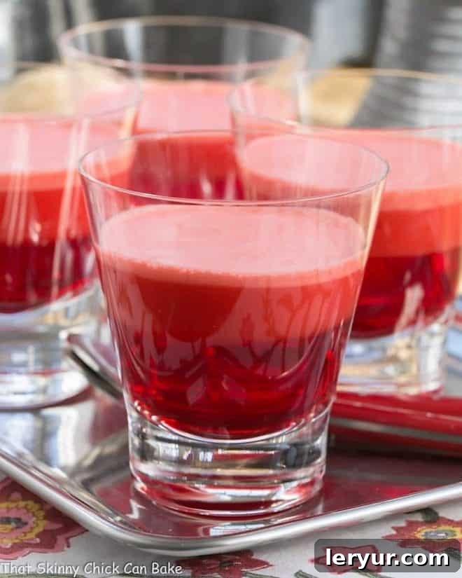 Close-up of a glass dish filled with layered 1-2-3 Jello, showing the distinct clear, creamy, and frothy layers.