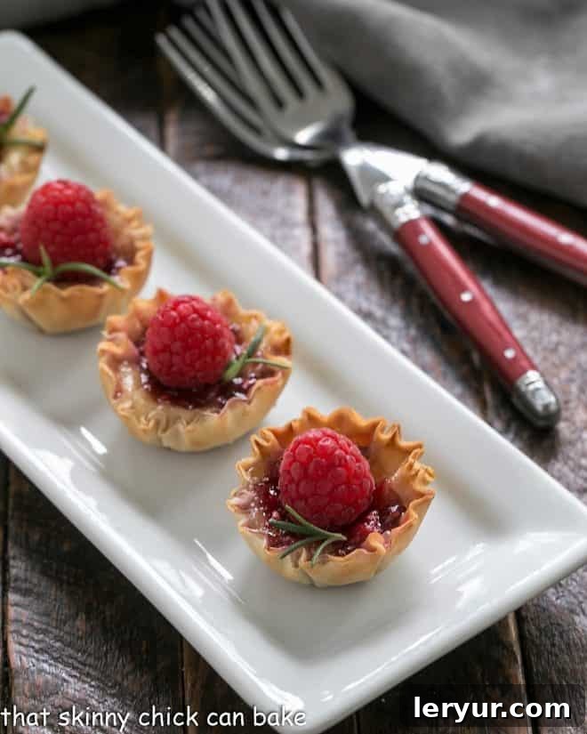 Baked Brie appetizers arranged neatly on a white rectangular serving tray, ready to be enjoyed.
