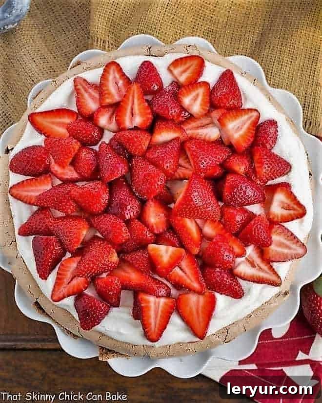 Strawberry Topped Chocolate Pavlova Recipe - A chocolate meringue topped with mascarpone cream and luscious strawberries Strawberry Topped Chocolate Pavlova overhead shot on a ruffled white cake plate
