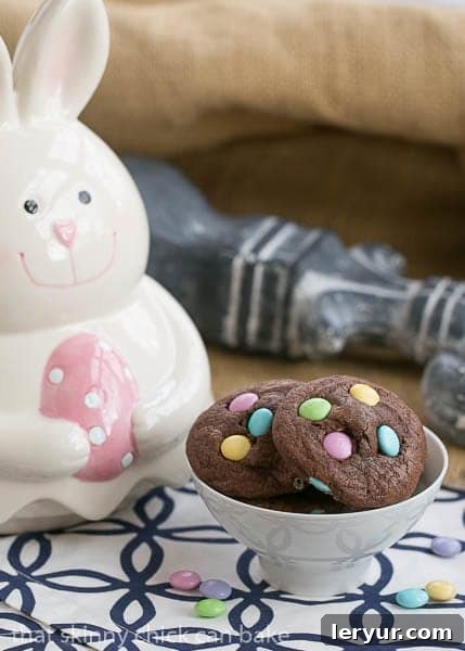 Overhead shot of rich, dark Chocolate Cookies featuring pastel Easter M&Ms, arranged artfully to show off their vibrant colors and perfect round shapes.
