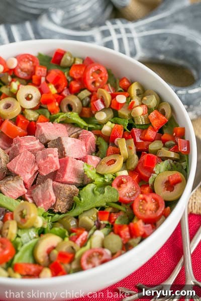A vibrant close-up of the Next-Day Beef Salad, highlighting the crisp greens, colorful vegetables, and creamy dressing.