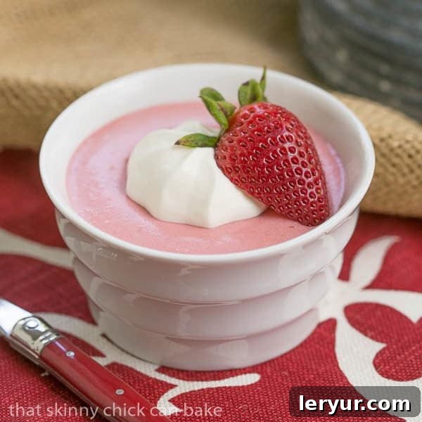 A single serving of Easy Strawberry Mousse, beautifully presented in a white ramekin, resting on a charming red and white checkered napkin, highlighting its delicate texture.