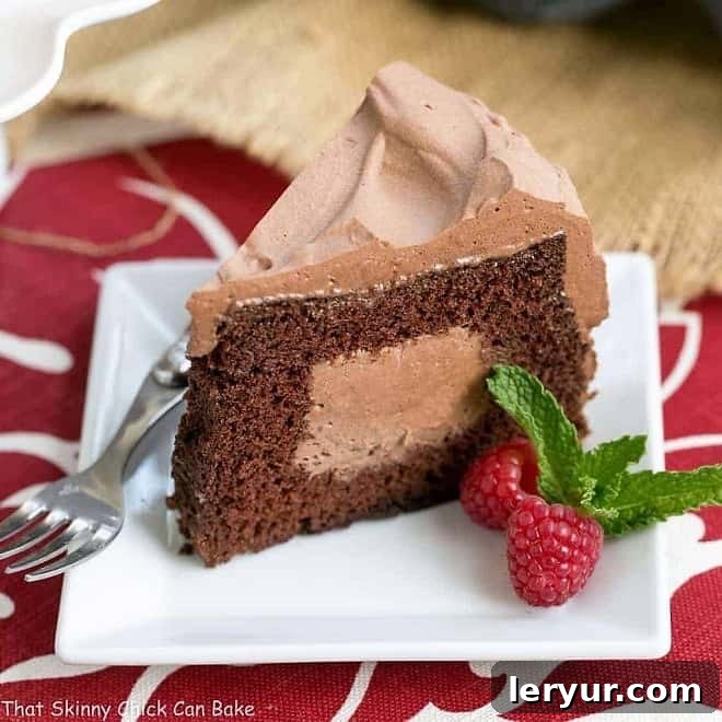 A perfectly sliced piece of Tunnel of Mousse Cake on a square white dessert plate, revealing the rich chocolate mousse filling.