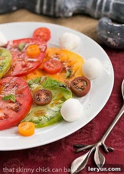 Salade de Tomates et Fromage - A French interpretation of a classic Italian salad, brimming with fresh flavors. Close-up of Salade de Tomates et Fromage on a white ceramic plate, highlighting the fresh basil leaves and the smooth texture of mozzarella.