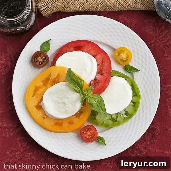 Salade de Tomates et Fromage - A refreshing and simple French salad with tomatoes, mozzarella, and basil. Overhead view of a beautifully arranged Salade de Tomates et Fromage on a white basketweave plate, highlighting its elegant presentation.