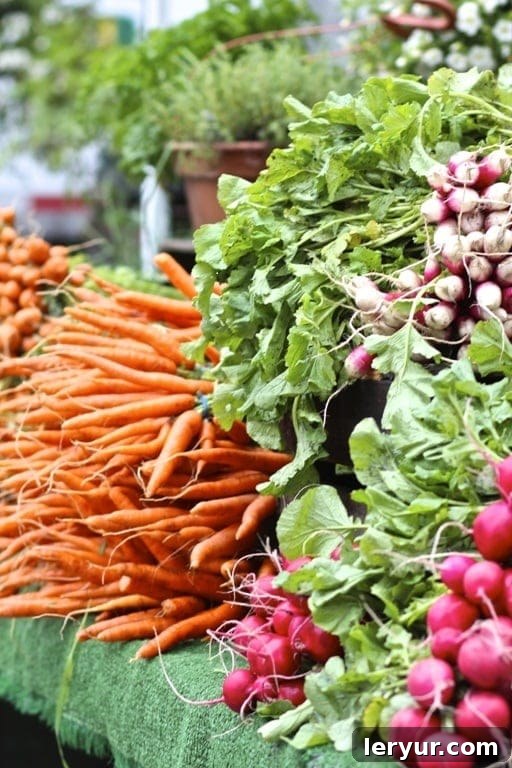 A vibrant close-up photo of fresh spring carrots with green tops