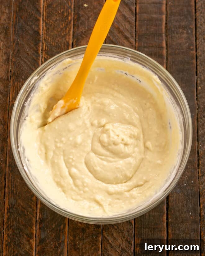 Fluffy Buttermilk Pancakes 5 A bowl of dry ingredients including flour, baking soda, and baking powder, with a melted butter in a small cup, ready to be combined with the wet ingredients for buttermilk pancakes.