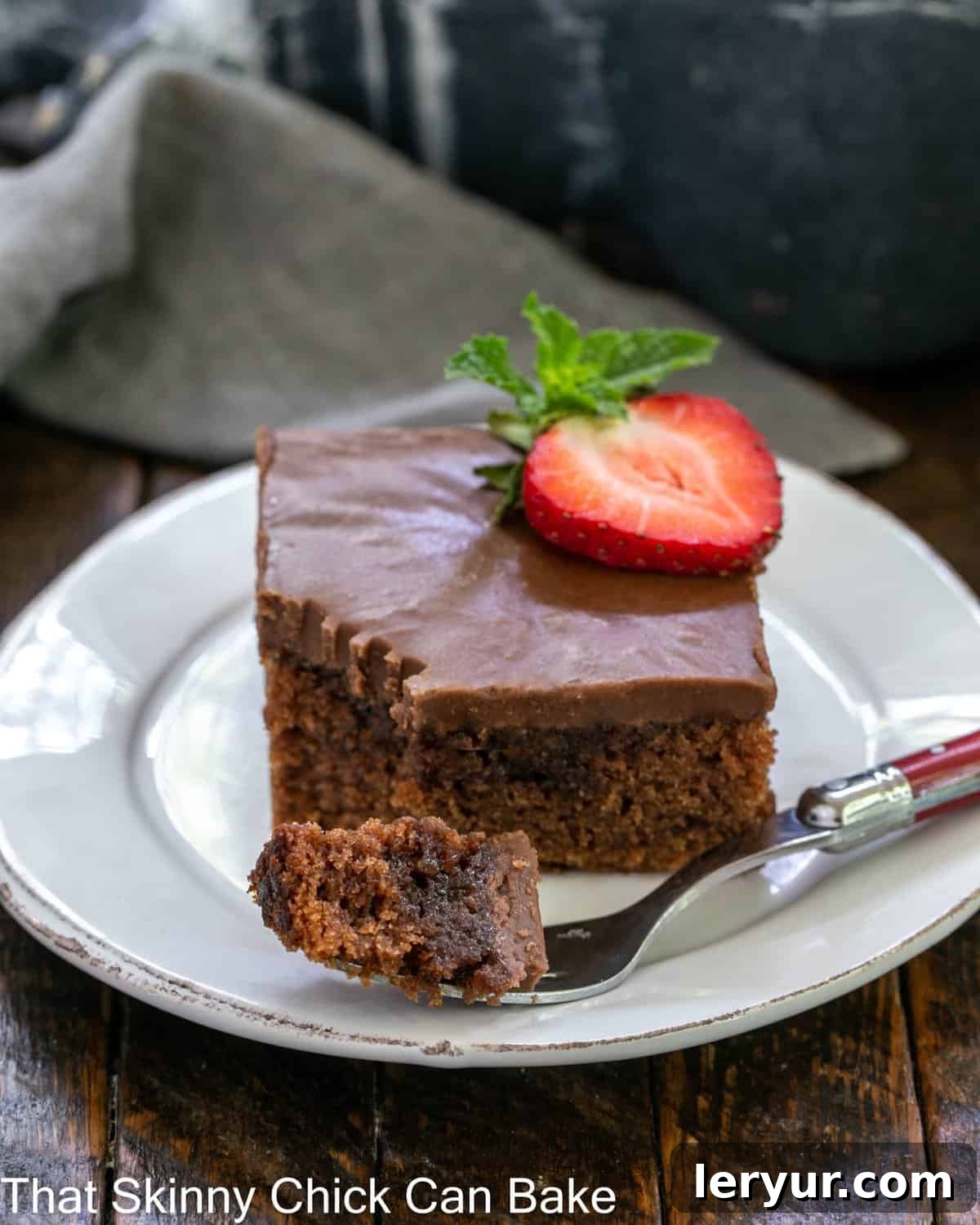 Classic Coca Cola Cake - An incredibly moist, decadent chocolate cake with Coke in the batter and frosting! coca cola cake with a bite removed on a red handled fork.