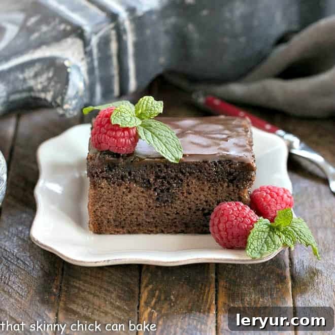 Classic Coca Cola Cake - An incredibly moist, decadent chocolate cake with Coke in the batter and frosting! A slice of Coca Cola Cake on a square white plate.