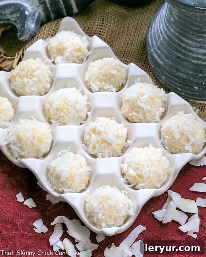 A charming close-up of Coconut White Chocolate Truffles nestled in a rustic ceramic egg crate, highlighting their irresistible texture and inviting appearance.