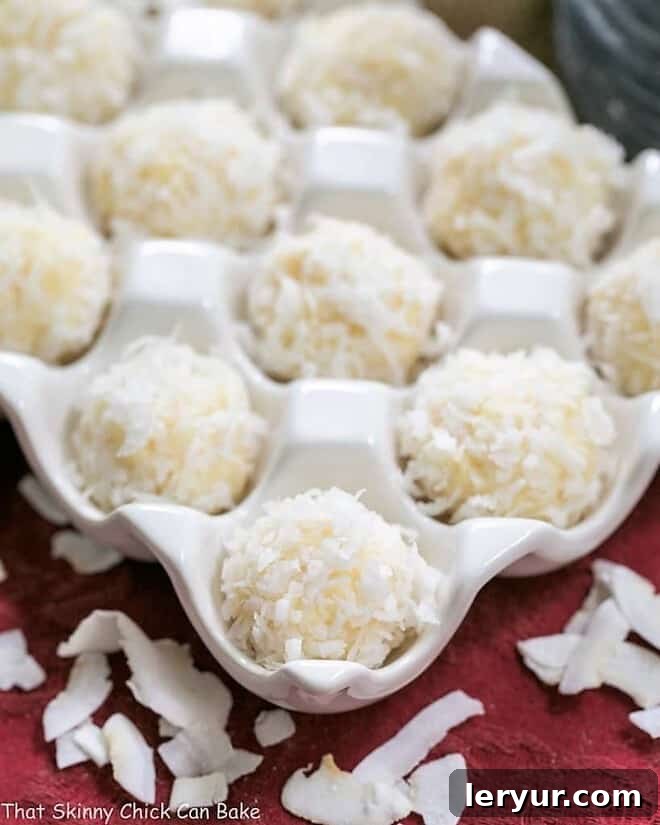 An irresistible close-up view of Coconut White Chocolate Truffles, perfectly coated and artfully arranged in a ceramic egg crate, beckoning with their creamy sweetness.