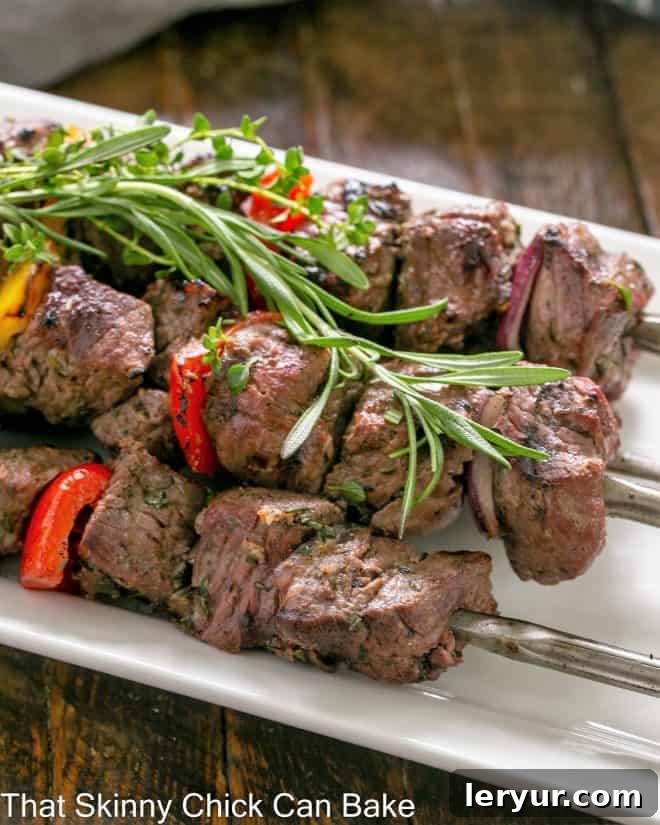 Close up of skewered lamb kebabs on a white serving tray