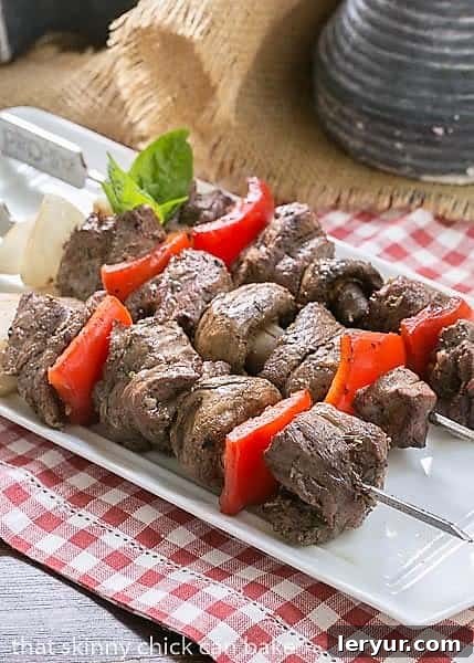 Tender Grilled Beef Steak Kabobs with a simple, flavor packed marinade Skewered Grilled Beef Steak Kabobs with vegetables on a white tray