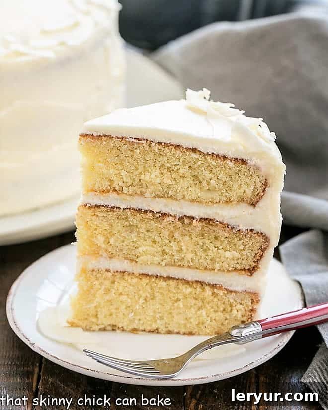 Decadent Italian Cream Cake 2 A stunning slice of Italian Cream Cake, showcasing its moist coconut layers and rich cream cheese frosting, presented beautifully on a white dessert plate.