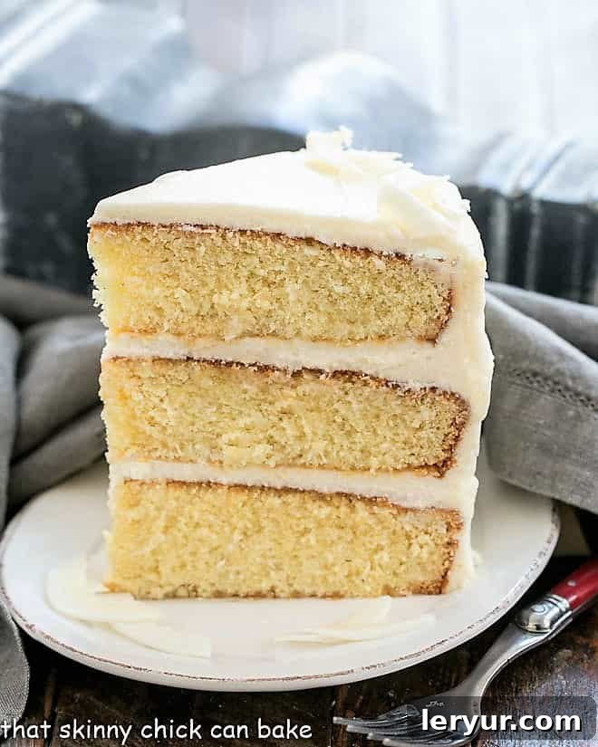 Decadent Italian Cream Cake 5 A perfect slice of Italian Cream Cake, showing off its beautiful coconut layers and rich cream cheese frosting, artfully placed on a pristine white dessert plate.