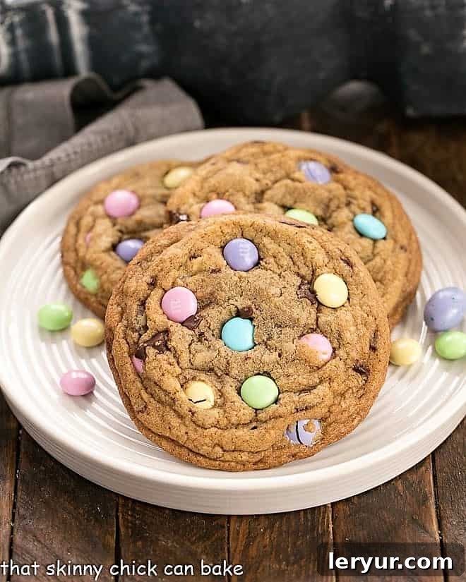 3 Brown Butter Easter Cookies on a rimmed white place surrounded by pastel M&M's