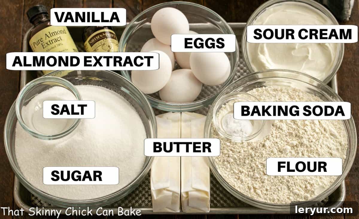 A curated display of all essential ingredients for a delicious sour cream pound cake, neatly arranged on a baking sheet, ready for preparation.