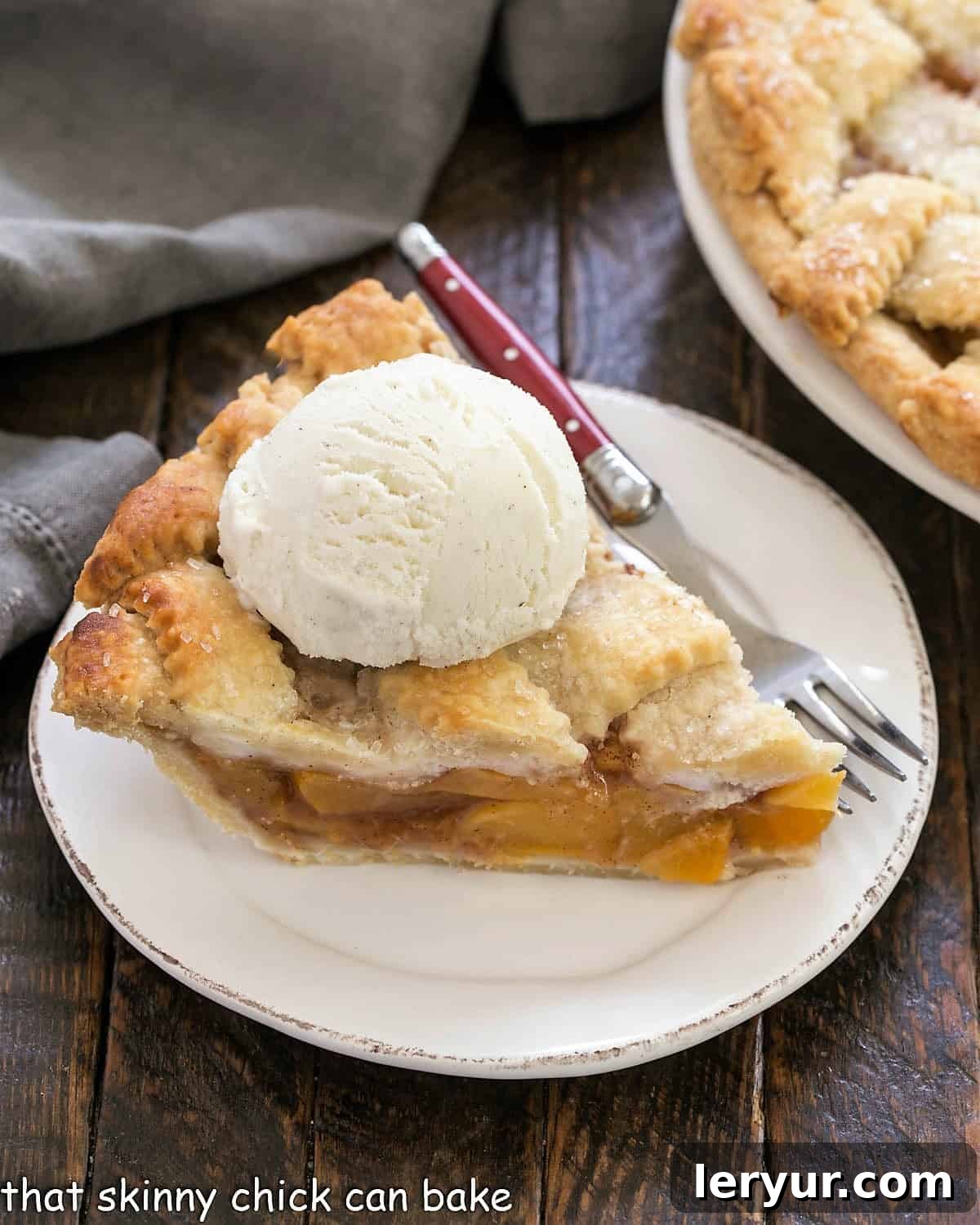 Best Peach Pie Recipe - A flaky lattice crust topping sweet and juicy peach filling A slice of Peach Pie on a white plate with a scoop of ice cream.