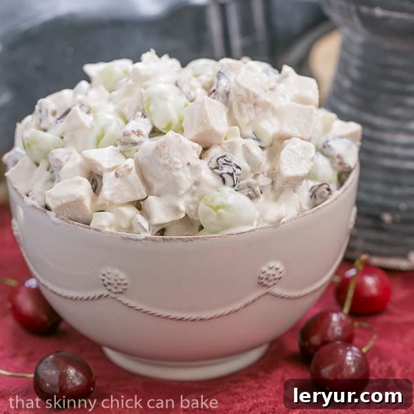 Fruity Chicken Salad - A Classic Chicken Salad jazzed up with dried cherries, grapes and pecans A bowl of Chicken Salad on a red napkin, ready to be served, highlighting its creamy texture and visible ingredients.