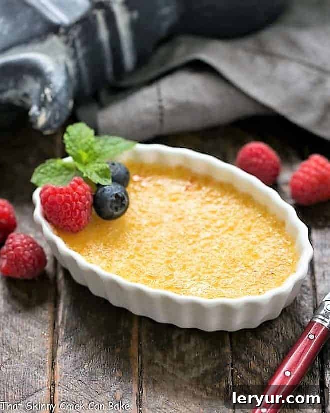 White Chocolate Crème Brûlée in a white ramekin. The perfect caramelized topping gleams under the light, hinting at the creamy delight beneath.