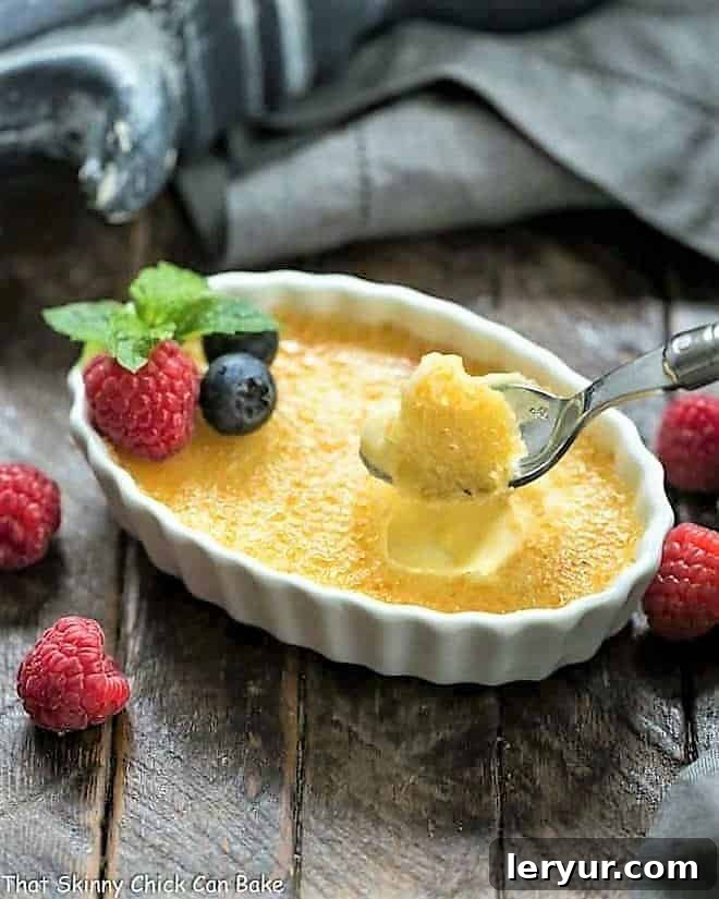 White Chocolate Crème Brûlée in a white ramekin with a spoon, showing the perfect texture of the custard and crisp topping.