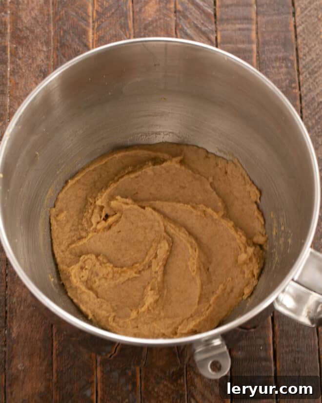 Chewy Oatmeal Caramel Delights 3 Overhead process shot demonstrating the initial step of combining softened butter and brown sugar in a bowl, followed by the addition of eggs and vanilla extract, ready for mixing.