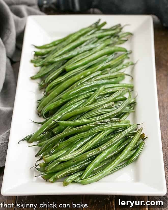 Vibrant Asian Green Beans Recipe served on a pristine white ceramic platter, garnished with sesame seeds.