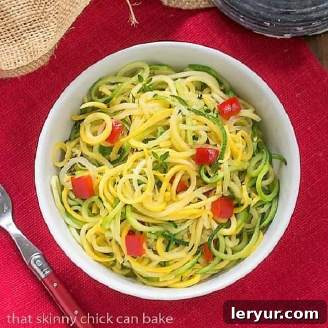 Zucchini Noodles with Parmesan - A light, healthy, low carb side dish! Vibrant Zucchini Noodles with Parmesan in a white bowl, resting on a rustic red napkin, highlighting freshness.