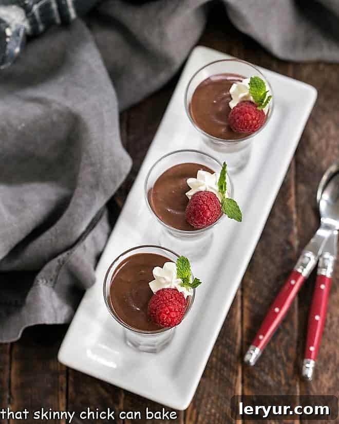 Overhead view of multiple servings of Blender Chocolate Mousse, neatly lined up on a white ceramic tray, showcasing their smooth, dark chocolate finish.