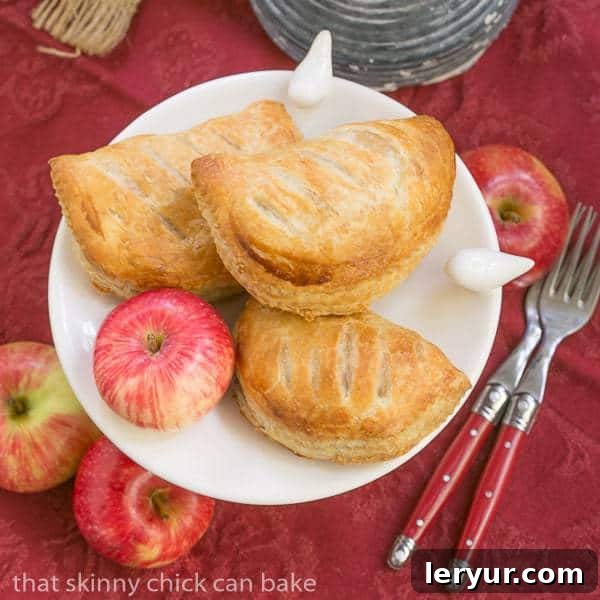 Chaussons aux Pommes - Easy delicious apple turnovers! Chaussons aux Pommes overhead view on a white serving dish on a red napkin.