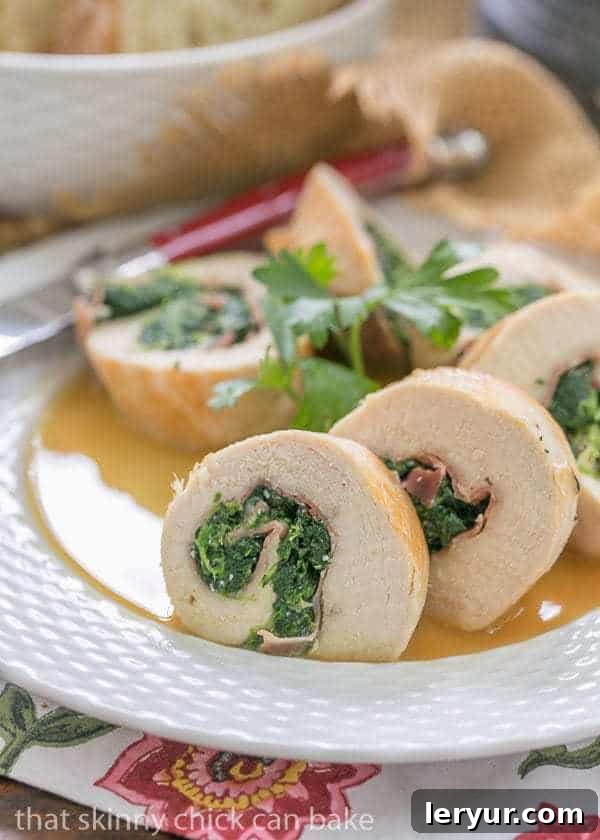 Close-up detail of a single Chicken Pinwheel with Spinach and Prosciutto, showcasing the golden-brown exterior and visible layers of filling.