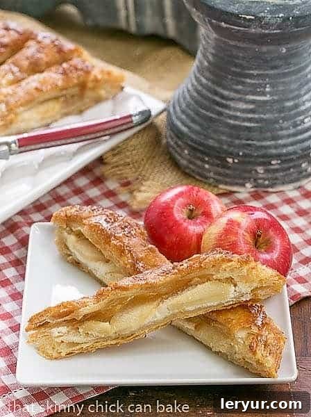 Close-up of a single slice of Maple Glazed Apple Tart, beautifully presented on a white ceramic plate, revealing the golden crust, creamy center, and artfully fanned apple slices.