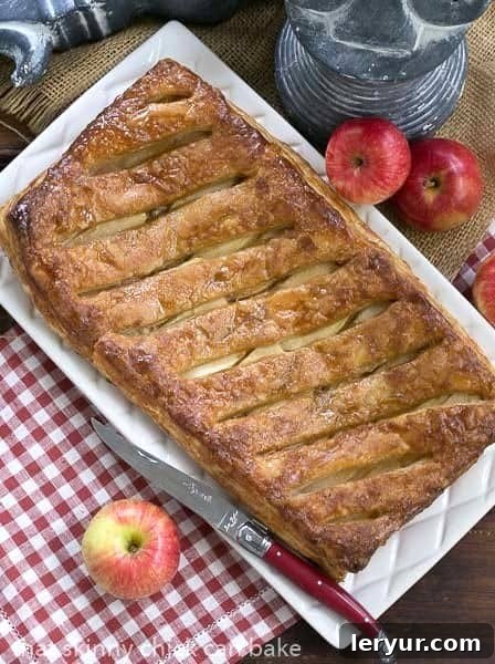 A stunning full view of the baked Maple Glazed Apple Tart, fresh from the oven, glistening with maple glaze, presented on a elegant white serving tray, ready for slicing.