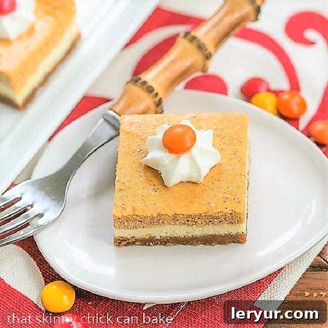 Pumpkin Cheesecake Bars on a small white plate, ready to be enjoyed.