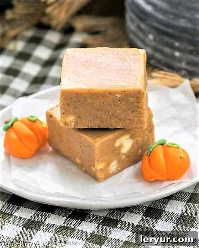 Easy Pumpkin Fudge - A simple, autumn spiced candy! Easy Pumpkin Fudge stacked on a white plate with candy pumpkins.