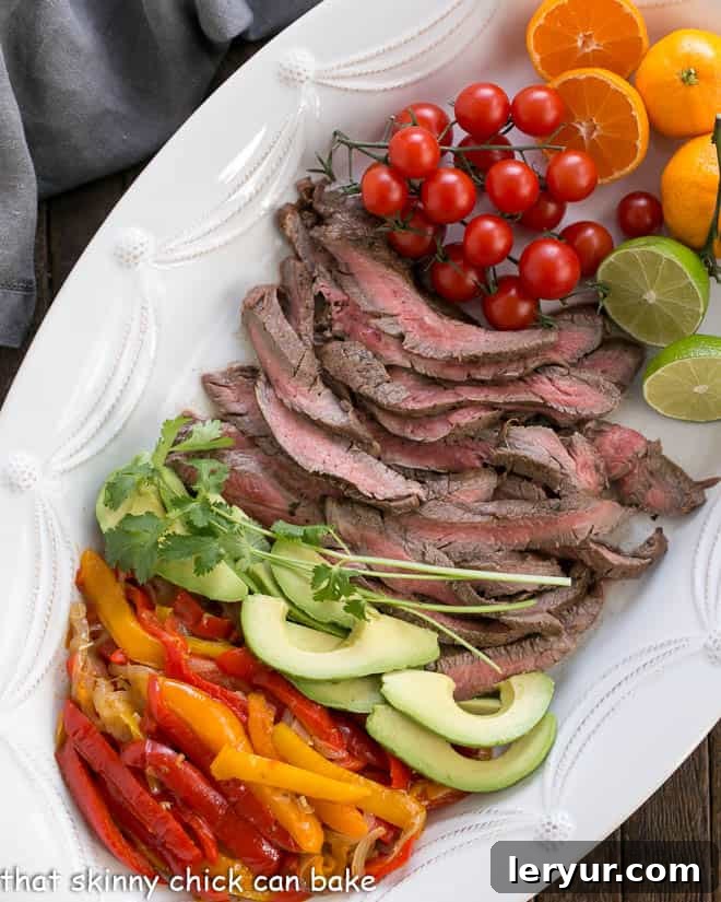 Easy Steak Fajitas Recipe and toppings from above on a white tray, highlighting the vibrant ingredients and fresh components of the meal.