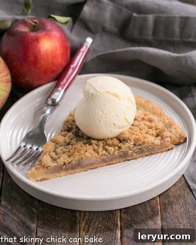 Apple Pie Pizza slice with a scoop of ice cream on a white dessert plate.